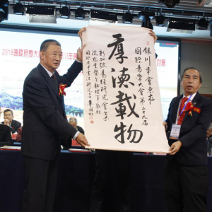 “2018国际易学大会第29届银川年会”新加坡易经研究会会长沈树圭向大会主席王少英赠送 ...